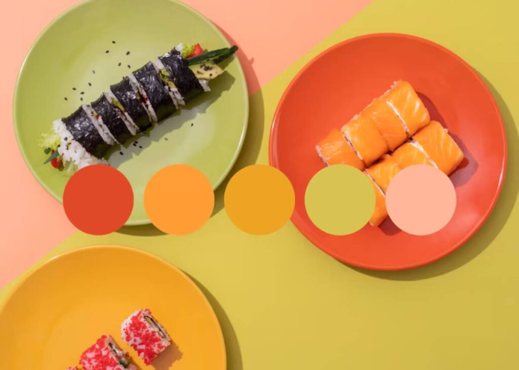An assortment of sushi rolls on vibrant plates, featuring colorful sushi on green and orange dishes against a yellow background.